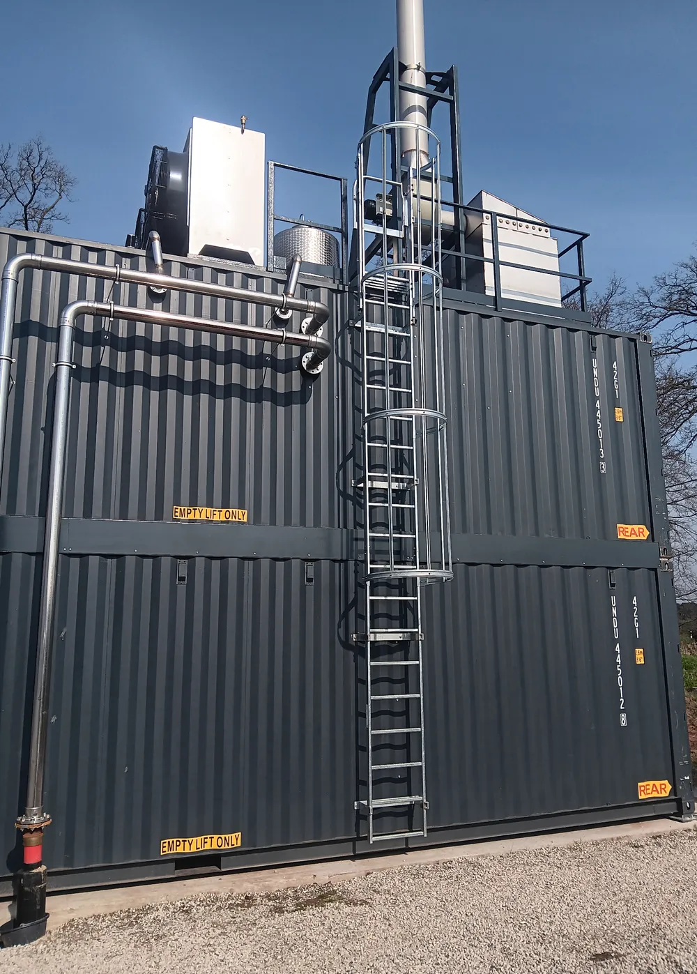 Feuerungsanlage in Containerbauweise mit Schornstein und Steigleiter