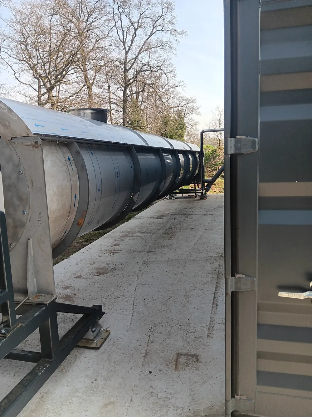 Trommeltrockner im Freien neben einem Anlagencontainer